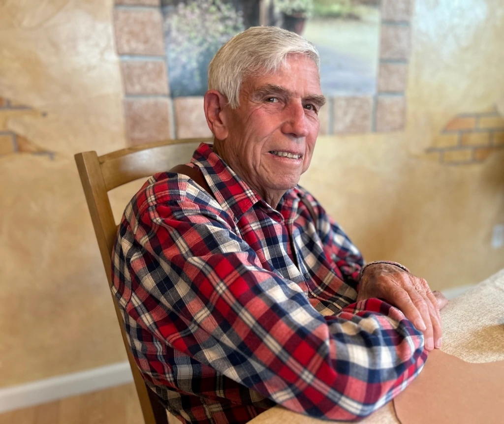 Nevada author and historian Dennis Cassinelli sits at a table in front of a faux brick wall.